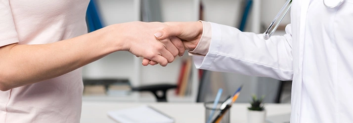 Close‑up of a doctor and a patient shaking hands